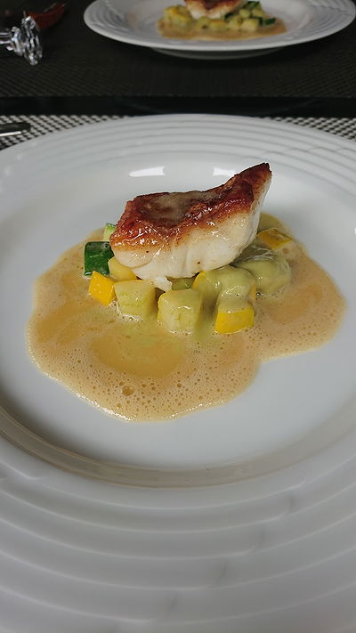 Gourmet fish dish with creamy sauce and vegetables