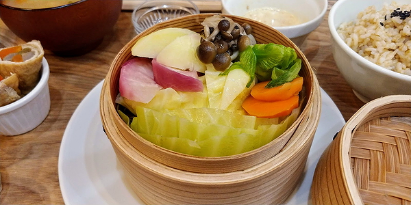 Assorted steamed vegetables in traditional bamboo steamer