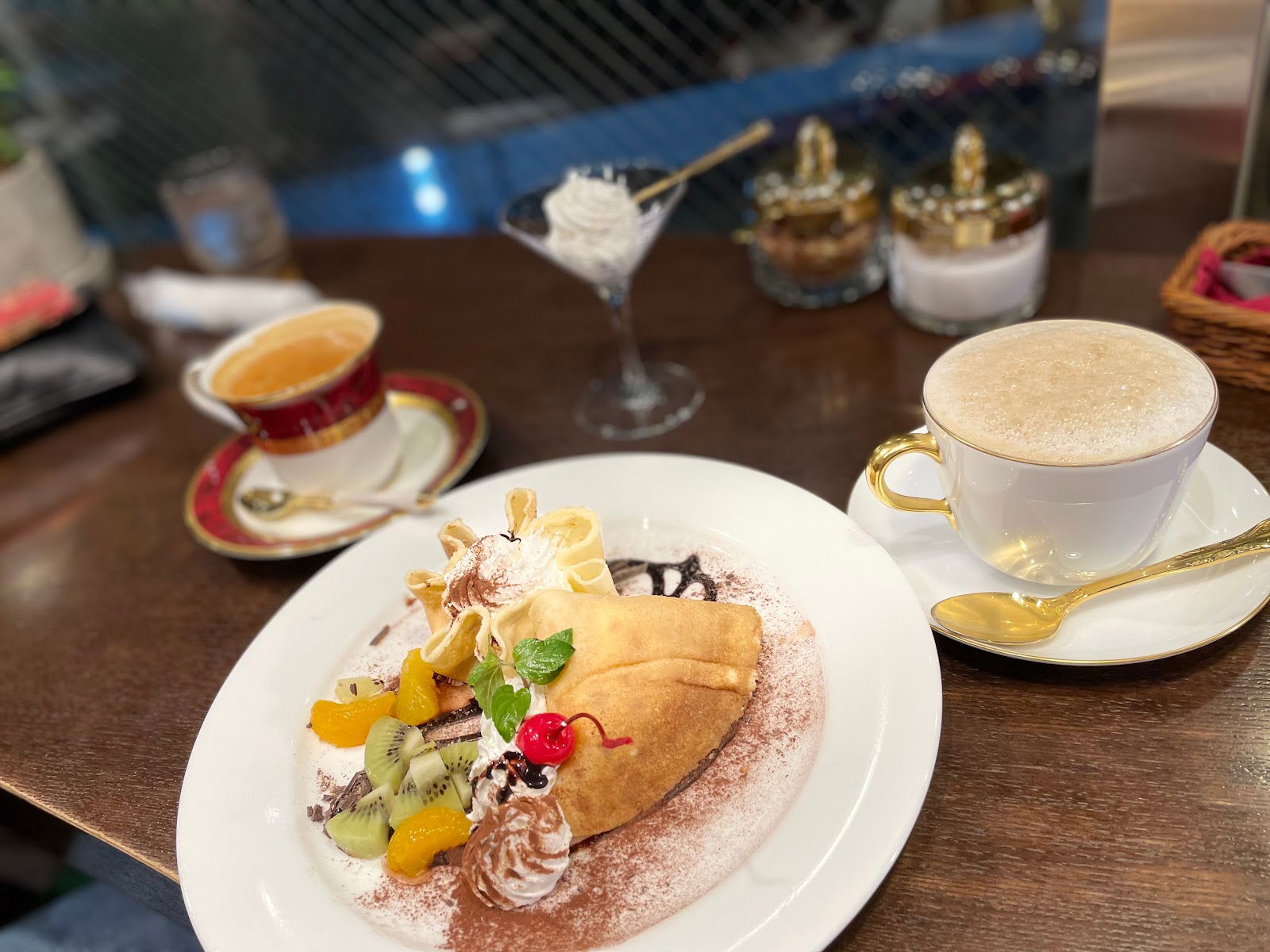 Coffee and dessert on a café table with fruit garnish