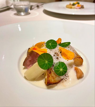 Elegant dish with foam garnish at fine-dining restaurant