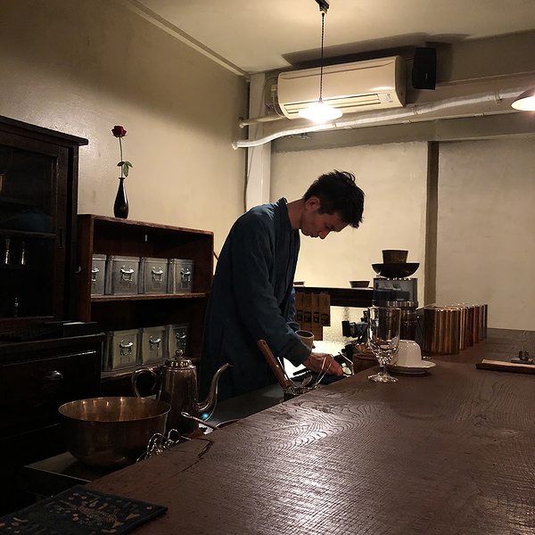 Cozy restaurant barista prepares coffee in dimly lit minimalist setting