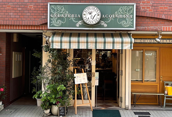 Charming gelateria entrance with striped awning and welcoming decor