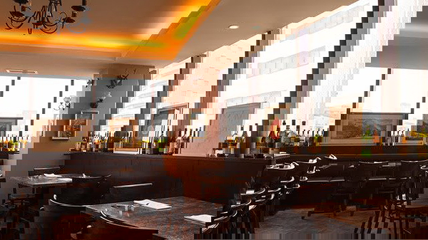Elegant restaurant interior with cozy lighting and wine displays.