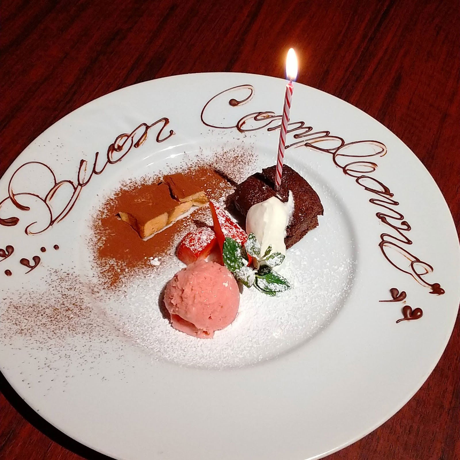 Gourmet dessert plate with Buon Compleanno message and candle