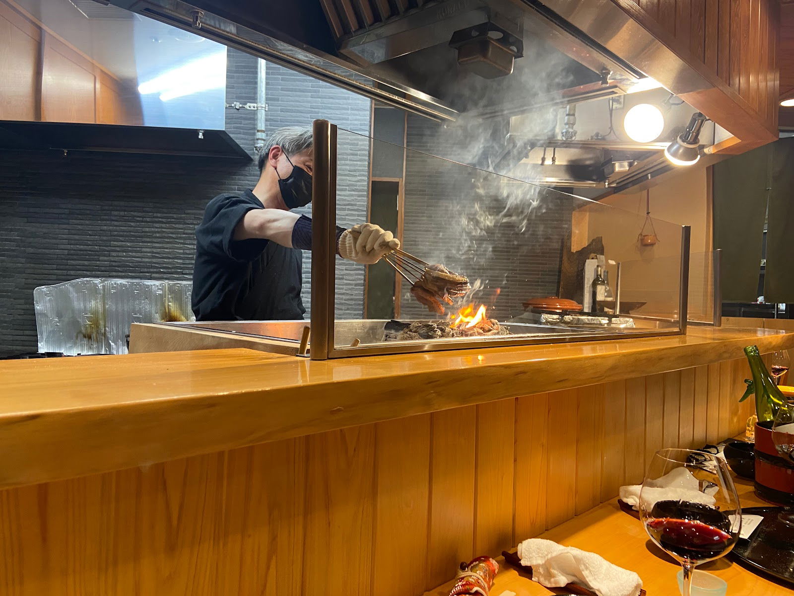 Chef grilling meat at upscale restaurant with open kitchen