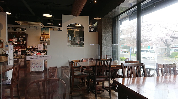 Cozy cafe interior with wooden tables and large windows