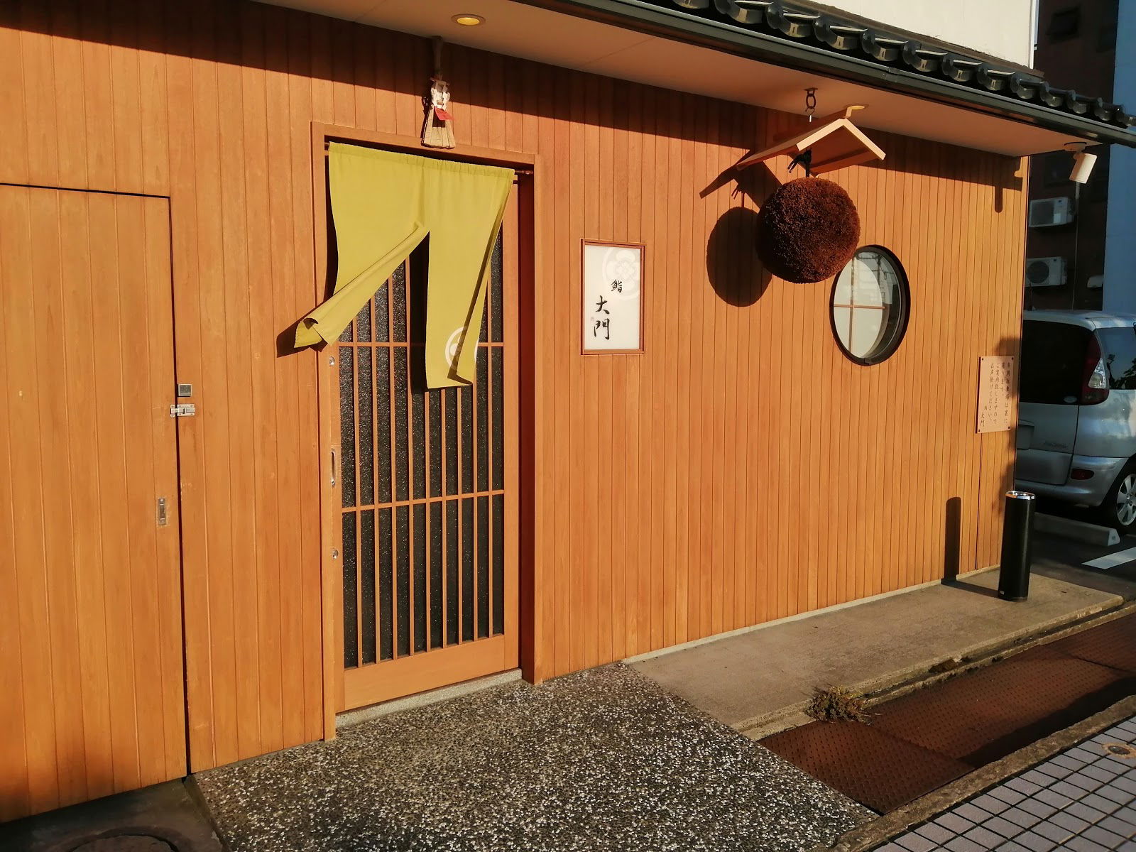 Cozy Japanese restaurant entrance with wooden facade and noren curtain