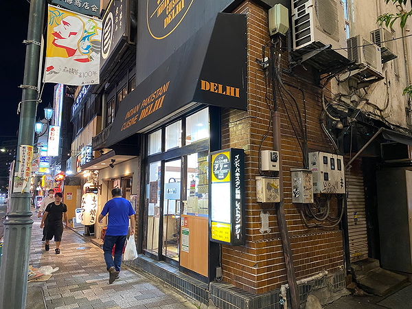 Cozy city street with a vibrant Indian restaurant front