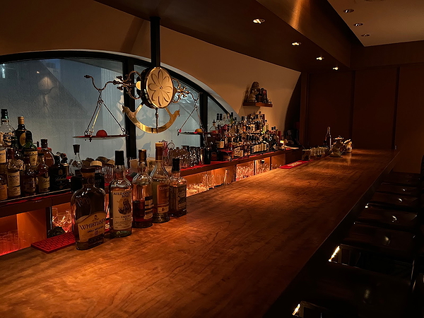 Cozy bar with wooden counter and variety of spirits on display