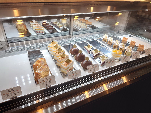 Assorted gourmet desserts displayed in a glass case at a restaurant