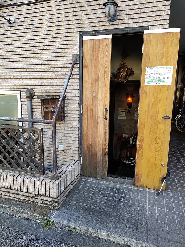 Cozy restaurant entrance with wooden door and warm interior lighting