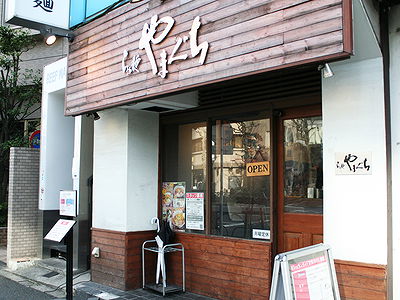 Rustic Japanese restaurant exterior with wooden sign and open door