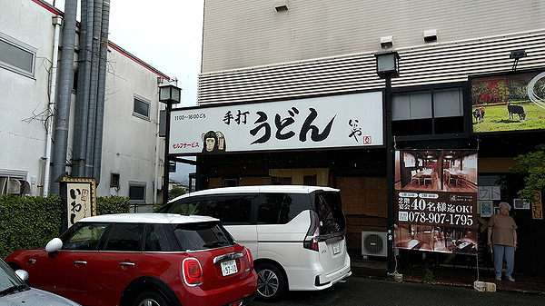Japanese udon restaurant exterior with signage and parked cars