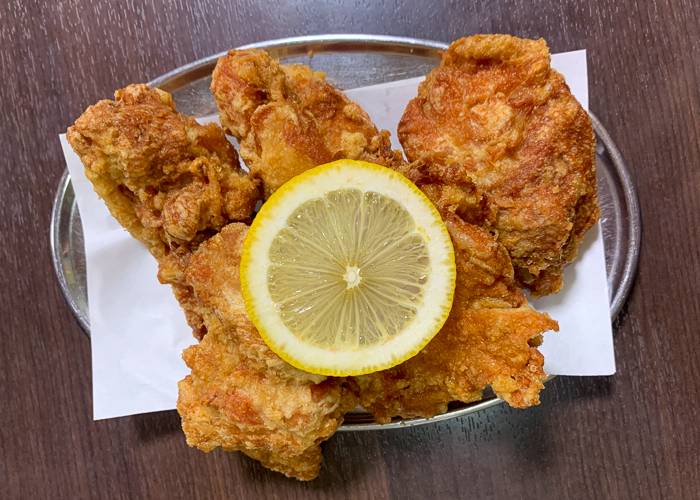 Karaage fried chicken on a plate with a round lemon slice on top
