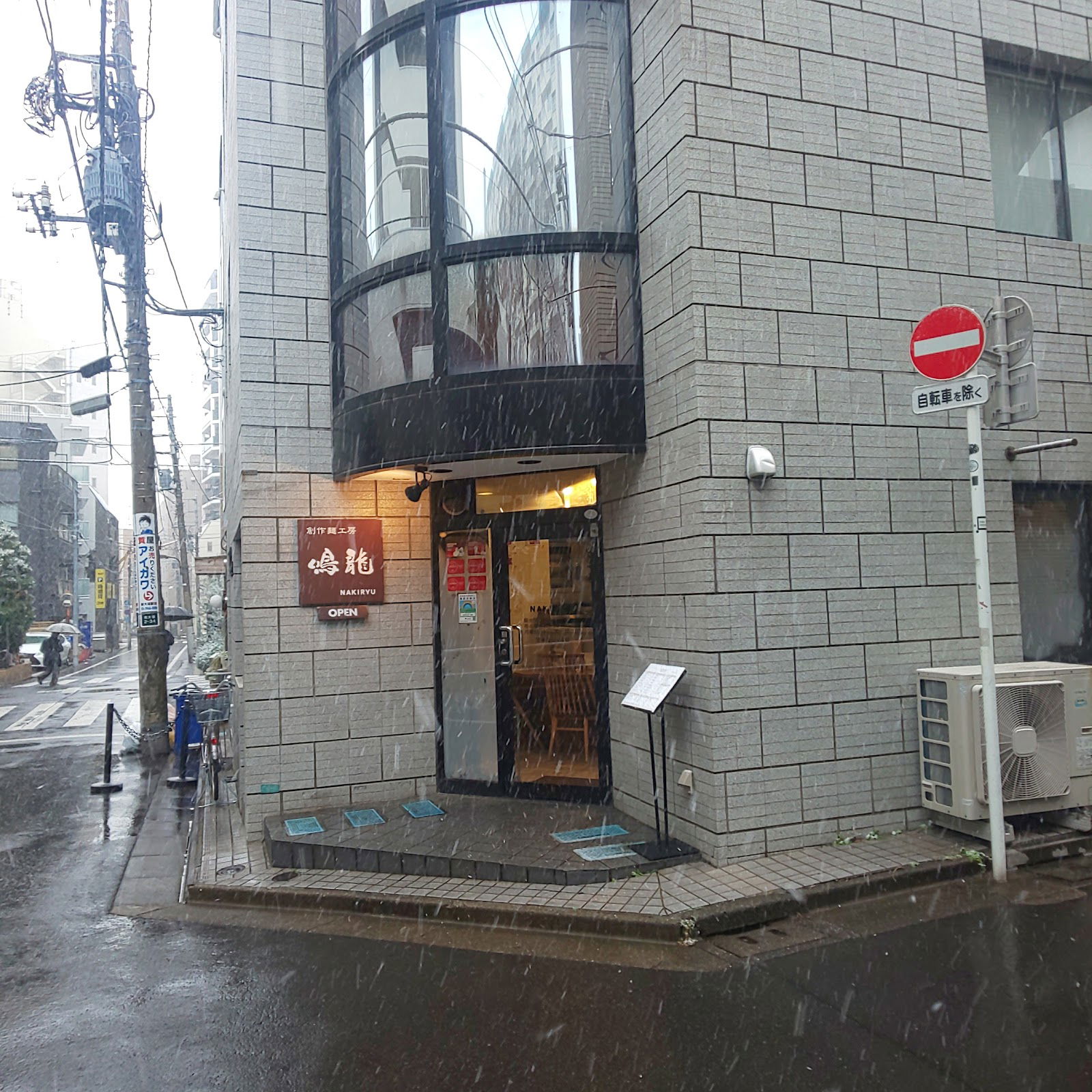 Cozy urban restaurant entrance on a snowy street corner