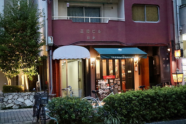Charming city cafe entrance with bicycles and greenery