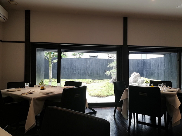 Elegantly set tables in a modern restaurant with garden view