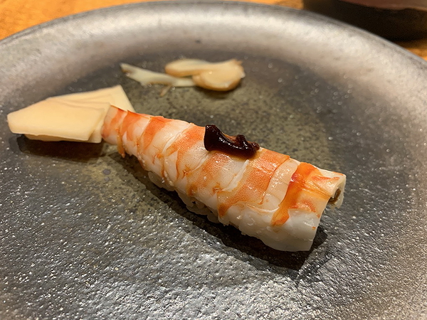 Fresh shrimp sushi garnished with sauce on a decorative plate