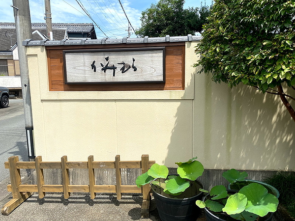 Charming restaurant exterior with traditional Japanese sign and greenery