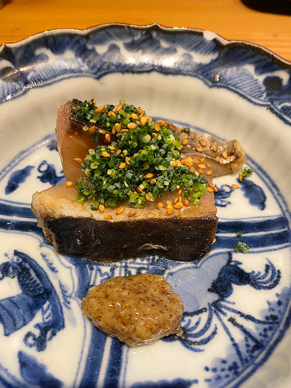 Gourmet fish dish with herbs on decorative porcelain plate