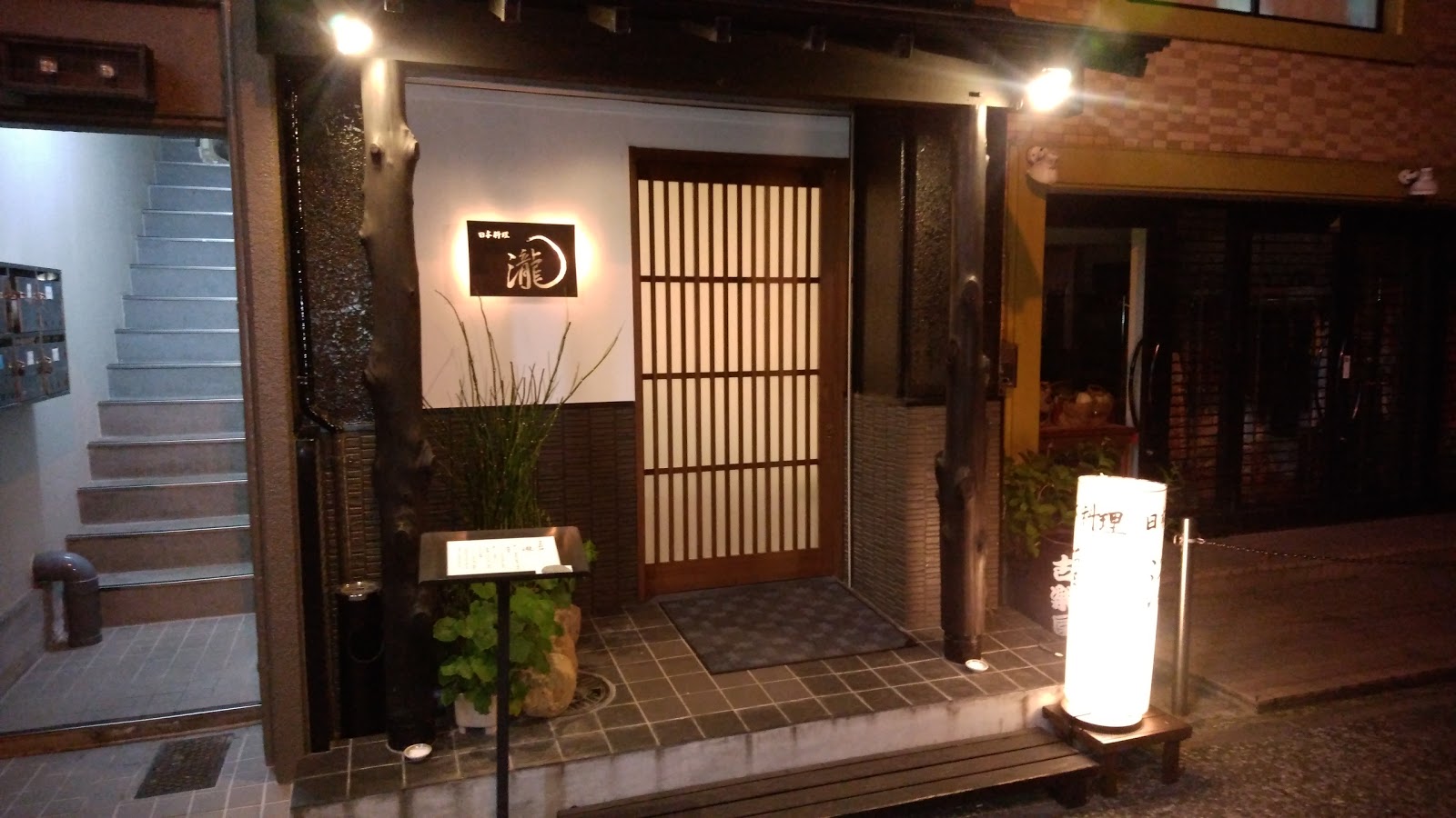 Traditional Japanese restaurant entrance at night.