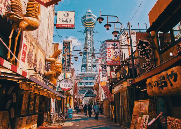 A photo of a street in Shinsekai with the Tsutenkaku Tower at the end