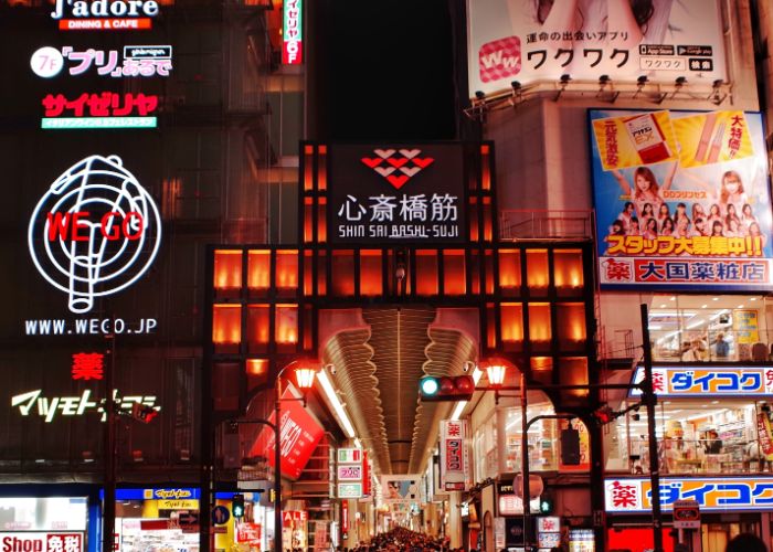 The entrance to the Shinsaibashi Suji shopping arcade at night, lit up in red 