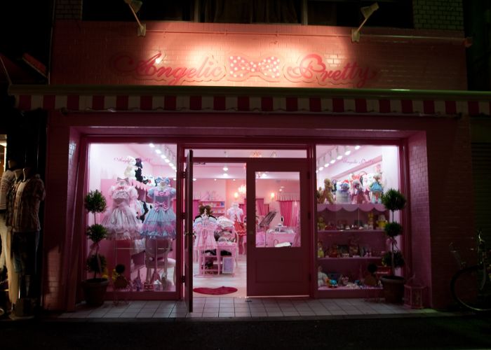 The pink Angelic Pretty clothing shop in Amemura at night, with dresses on display
