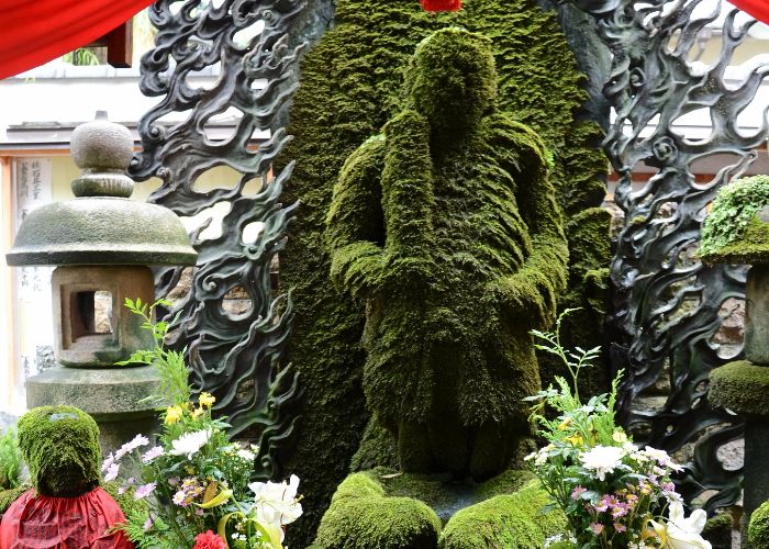 A green moss-covered statue at Hozenji Temple