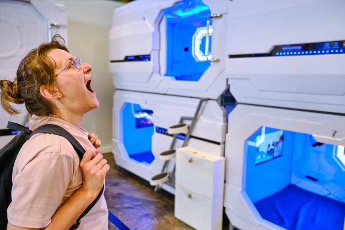 Women looks excited at the small rooms in a capsule hotel