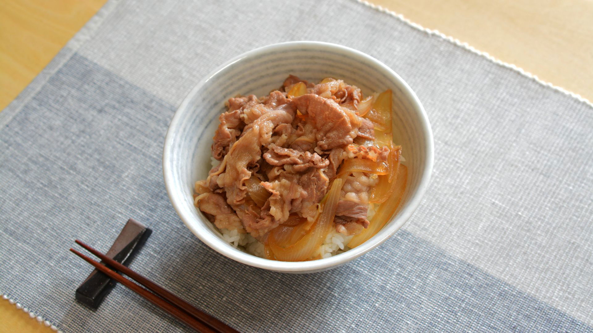 Delicious Gyudon served in a ceramic bowl with chopsticks on a mat