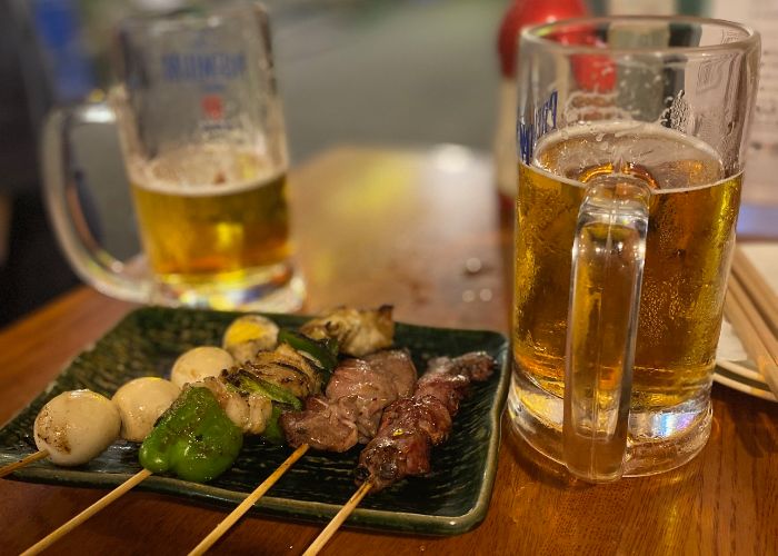 Two beers and a plate of yakitori