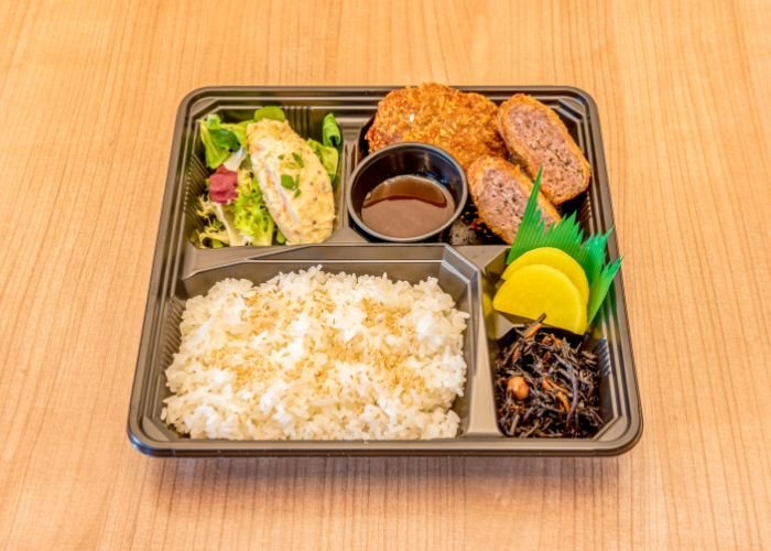 a bento box with rice and menchi katsu