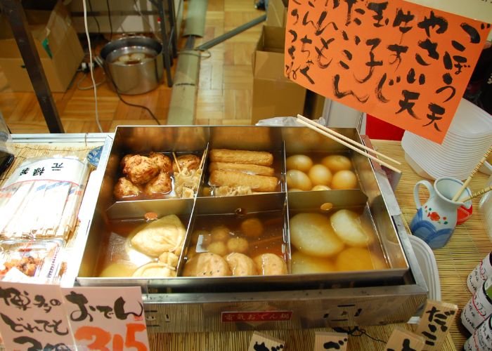 Self-serve oden in Fukuoka featuring kinchaku, signage, and a partitioned vat of ingredients and broth