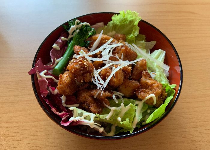 A bowl of salad topped with vegetarian fried karaage balls