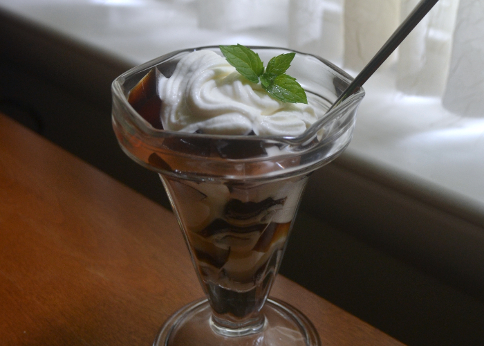 Japanese coffee jelly with whipped cream and a mint garnish in a parfait glass