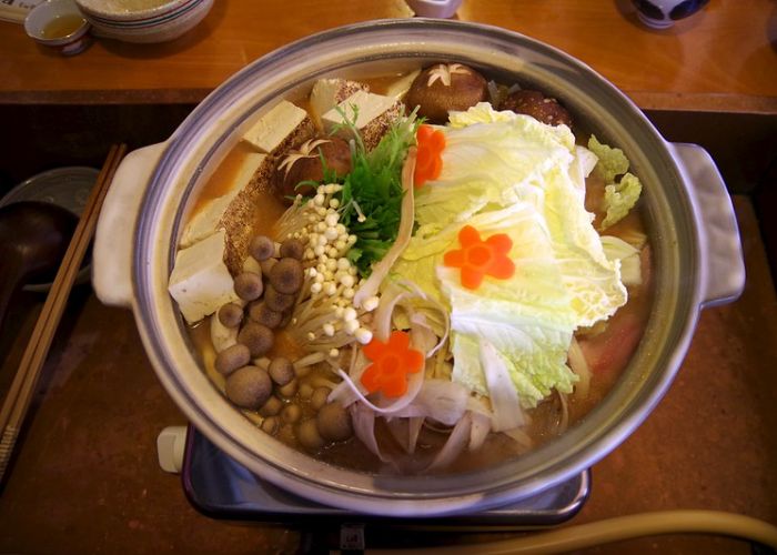 A classic nabe hot pot, featuring noodles, meats, tofu and vegetables soaking in a broth.