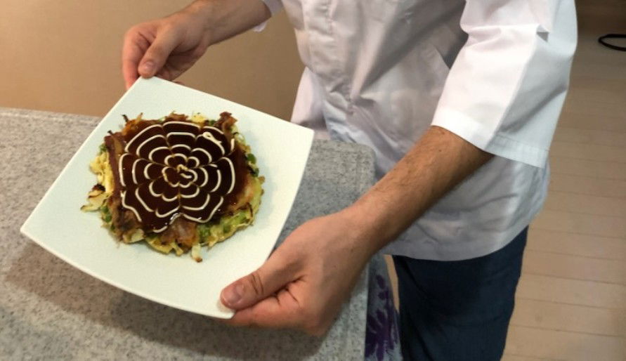 A cutely patterned okonomiyaki, made in this halal-friendly cooking class.