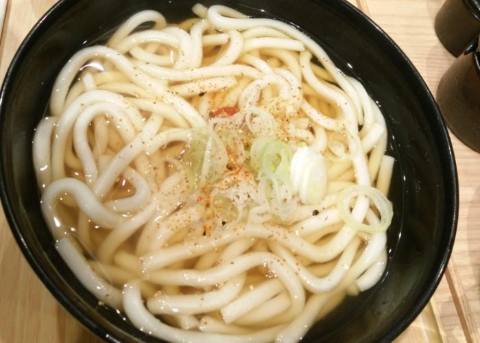 Udon noodles in a black bowl with light soup