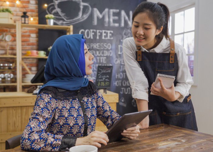 A woman orders food from a waitress