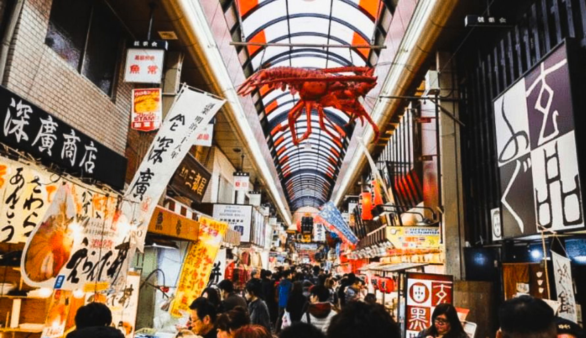Kuromon Market in Osaka, filled with people.