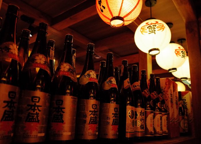 A row of shochu bottles, with lanterns above them
