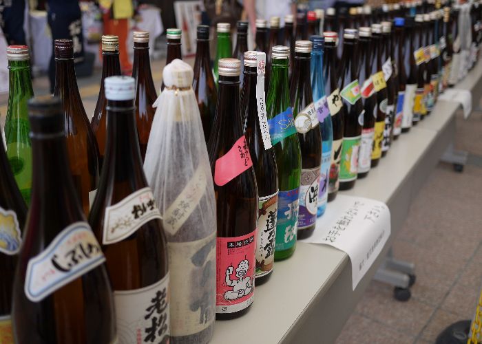 Several different bottles of shochu lined up in a row, leading diagonally away from the camera