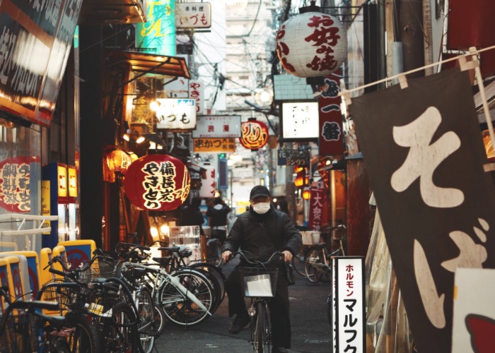 Man riding his bicycle through the backstreets of Osaka