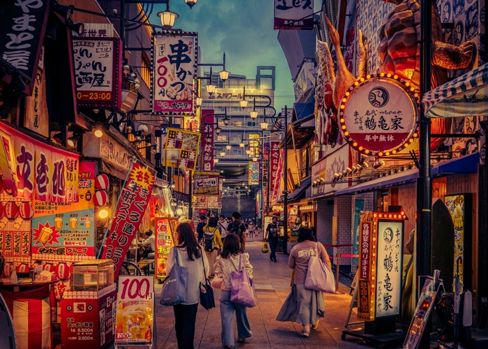 Osaka streets lined with bright lights, bars and street vendors