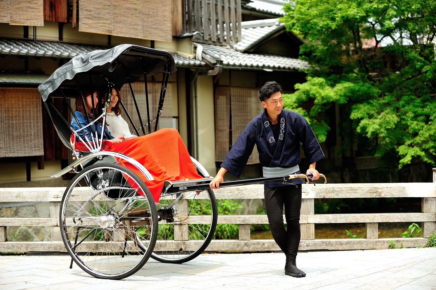 Two guests in a rickshaw, about to be escorted through the streets of Kyoto.