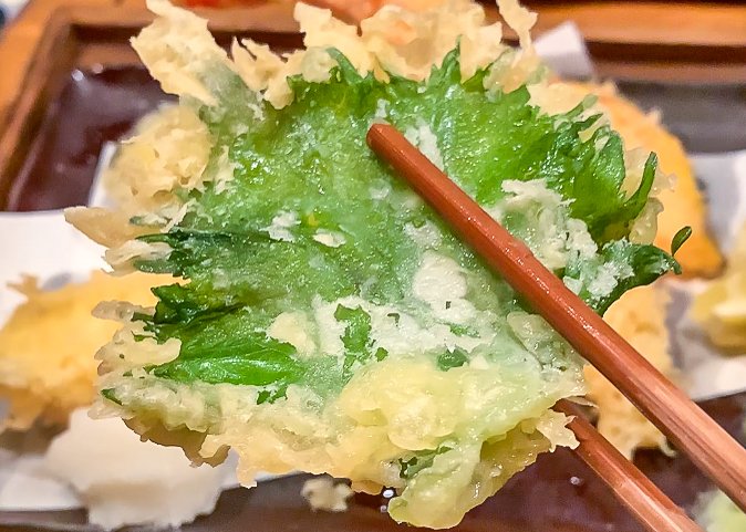 Shiso tempura held up by chosticks