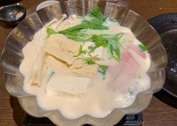A bowl of tonyu nabe with tofu and vegetables 
