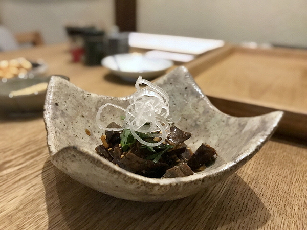 Gourmet beef dish in ceramic bowl at fine dining restaurant