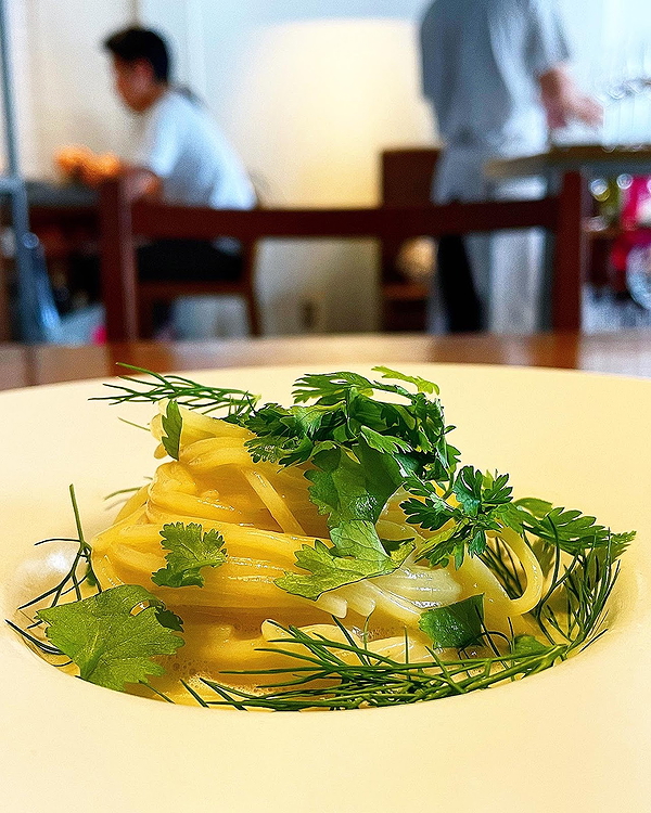 Gourmet pasta dish with herbs at a modern restaurant